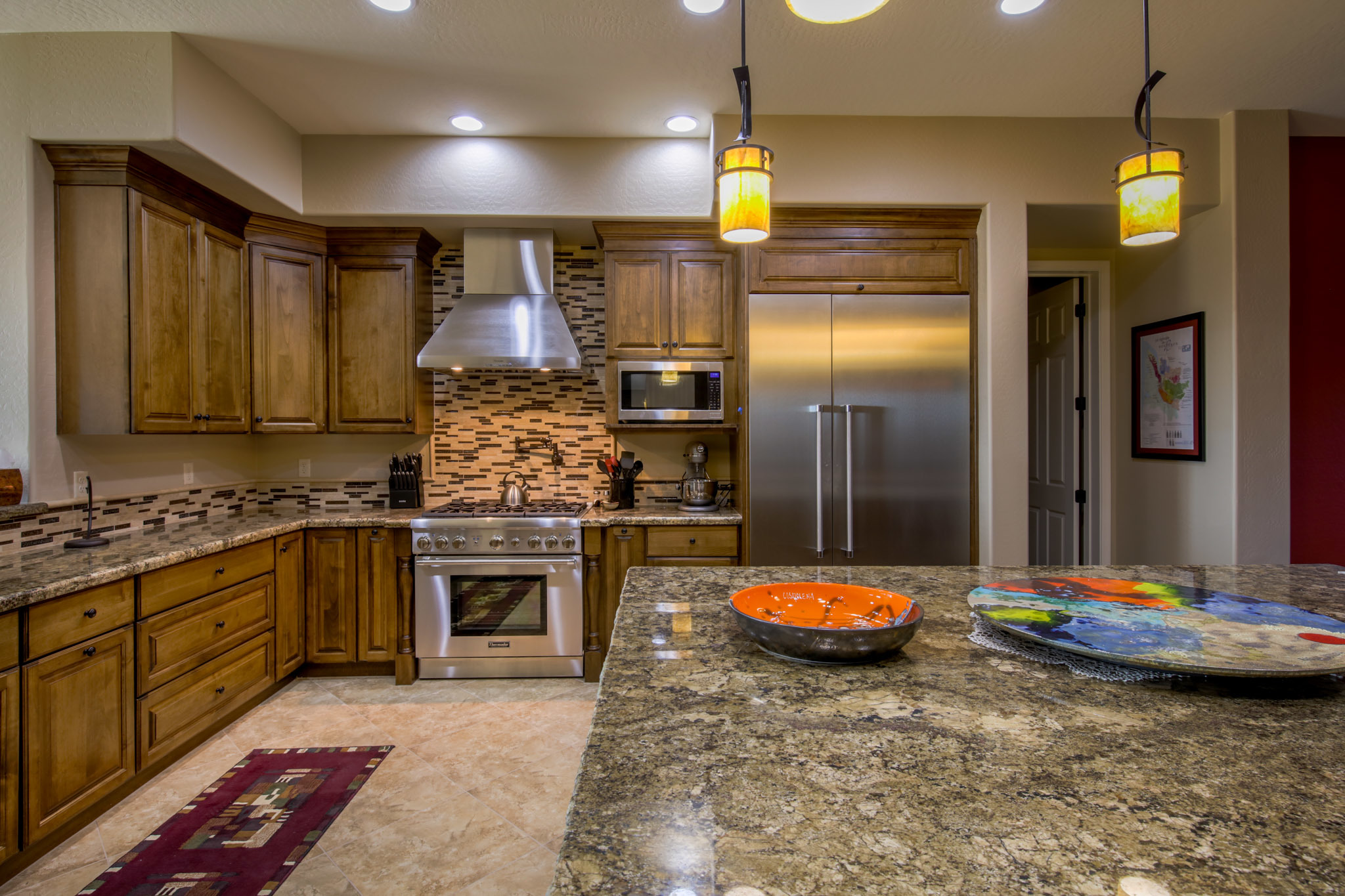 Kitchen remodel by Maverick Kitchens featuring Sollid cabinetry, granite island, and pendant lighting